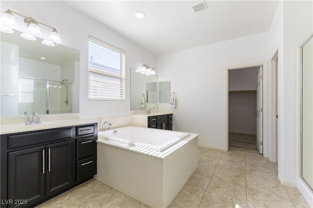 full bath featuring a stall shower, two vanities, tile patterned flooring, and a bath