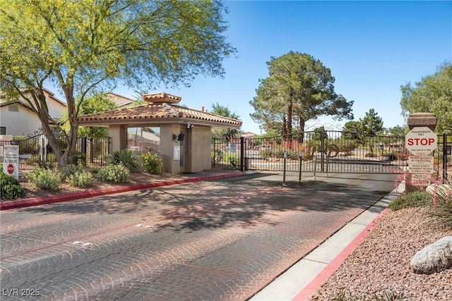 4821 Black Bear Rd Unit 101, Las Vegas, NV 89149 - view of decorative street with a gate, a gated entry, curbs, and traffic signs