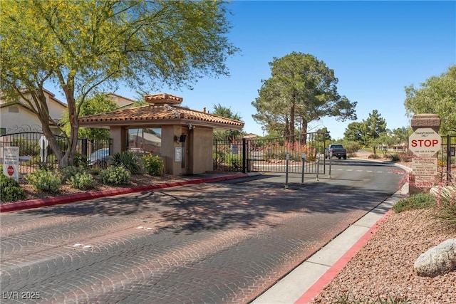 4821 Black Bear Rd Unit 101, Las Vegas, NV 89149 - view of decorative road featuring a gate, curbs, traffic signs, and a gated entry