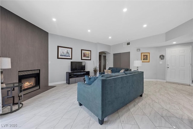 4821 Black Bear Rd Unit 101, Las Vegas, NV 89149 - living area featuring arched walkways, recessed lighting, light marble finish flooring, an accent wall, and baseboards