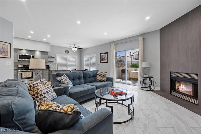 4821 Black Bear Rd Unit 101, Las Vegas, NV 89149 - living area with recessed lighting, light marble finish flooring, a fireplace, ceiling fan, and an accent wall