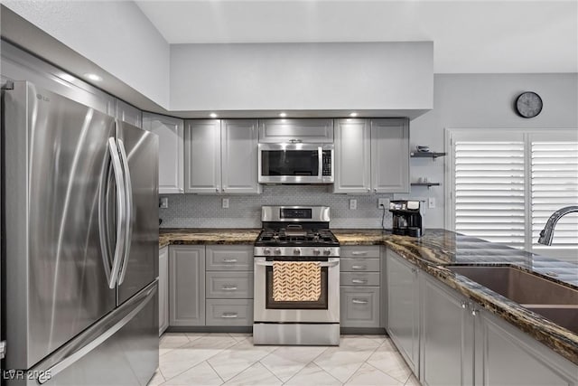 4821 Black Bear Rd Unit 101, Las Vegas, NV 89149 - kitchen with stainless steel appliances, gray cabinetry, a sink, and dark stone counters