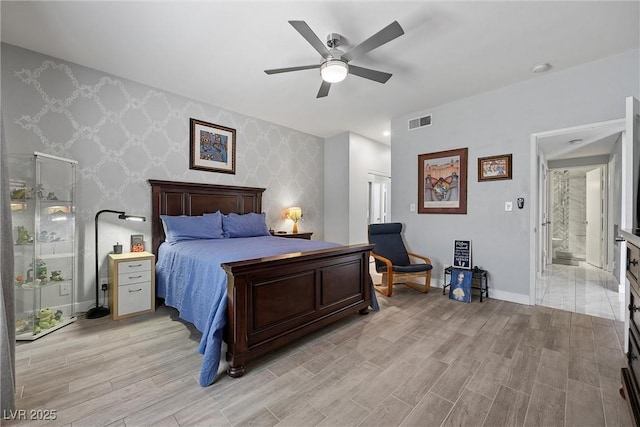 4821 Black Bear Rd Unit 101, Las Vegas, NV 89149 - bedroom with wallpapered walls, light wood-type flooring, baseboards, an accent wall, and a ceiling fan