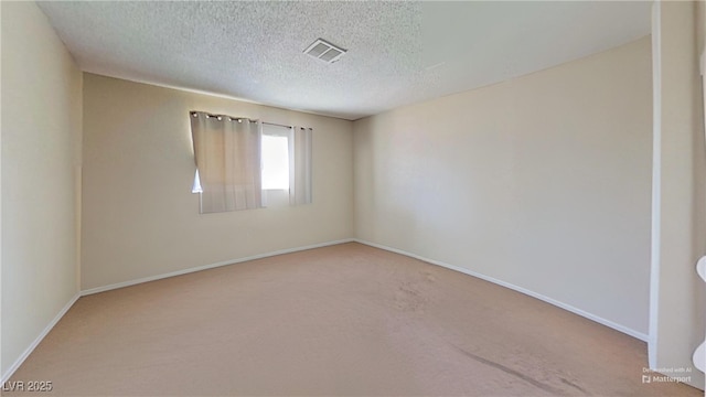 carpeted spare room featuring baseboards and a textured ceiling