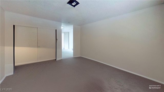 unfurnished bedroom featuring dark colored carpet, a closet, baseboards, and a textured ceiling