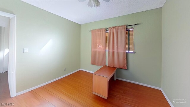 unfurnished room featuring baseboards, ceiling fan, and wood finished floors