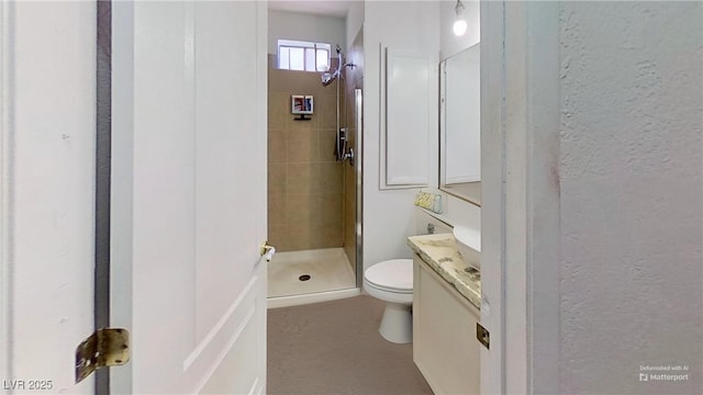 full bath with a shower stall, toilet, vanity, and a textured wall