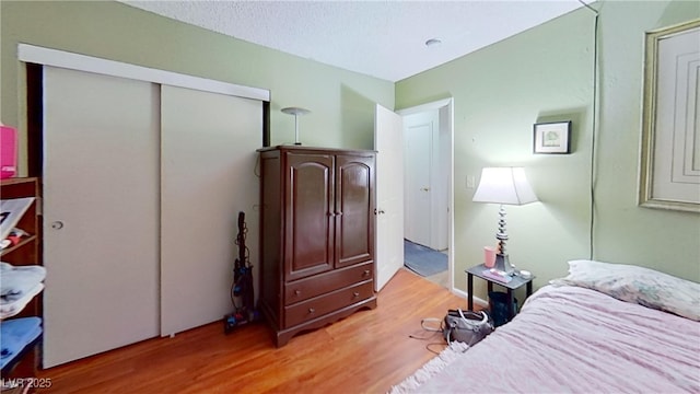 bedroom with light wood-style floors and a closet