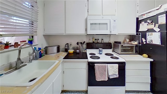 kitchen featuring range with electric cooktop, white microwave, a sink, white cabinets, and light countertops