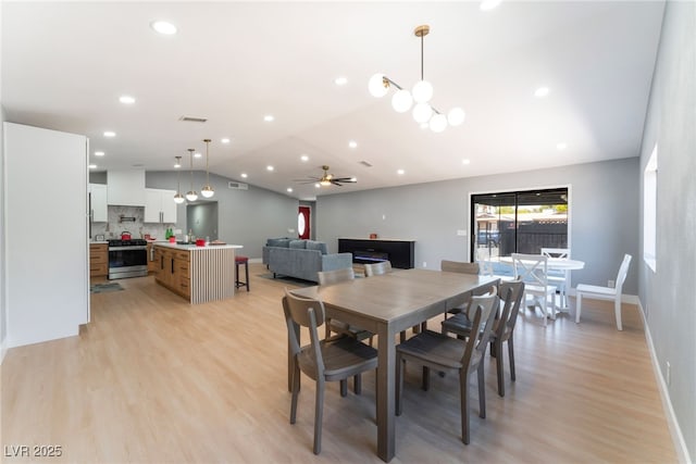 dining area with lofted ceiling, light wood finished floors, baseboards, a ceiling fan, and recessed lighting