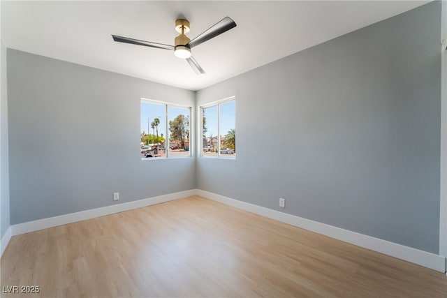 empty room with ceiling fan, light wood-style flooring, and baseboards