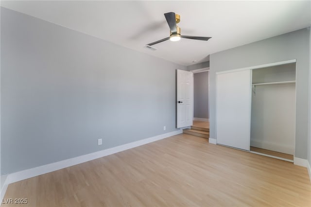 unfurnished bedroom with light wood-style flooring, baseboards, and a closet