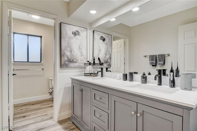 2224 Lucerne Ct, Henderson, NV 89014 - bathroom with baseboards, wood finished floors, double vanity, recessed lighting, and toilet