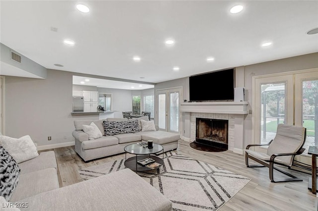 2224 Lucerne Ct, Henderson, NV 89014 - living room with baseboards, plenty of natural light, light wood-type flooring, a tile fireplace, and recessed lighting