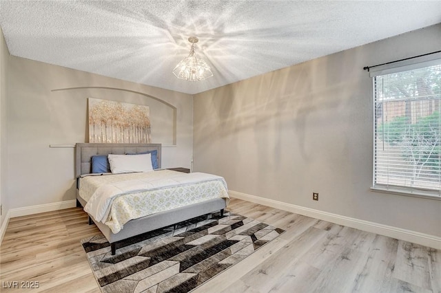 2224 Lucerne Ct, Henderson, NV 89014 - bedroom featuring a chandelier, light wood finished floors, baseboards, and a textured ceiling
