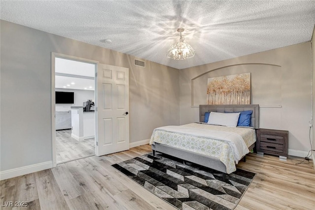 2224 Lucerne Ct, Henderson, NV 89014 - bedroom with a chandelier, wood finished floors, baseboards, and a textured ceiling