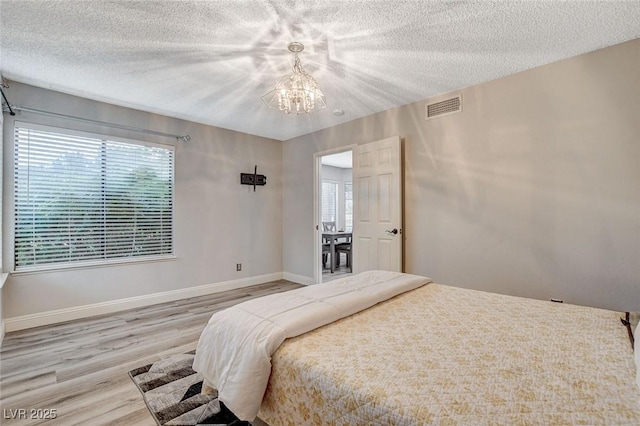 2224 Lucerne Ct, Henderson, NV 89014 - bedroom featuring a chandelier, wood finished floors, a textured ceiling, and baseboards