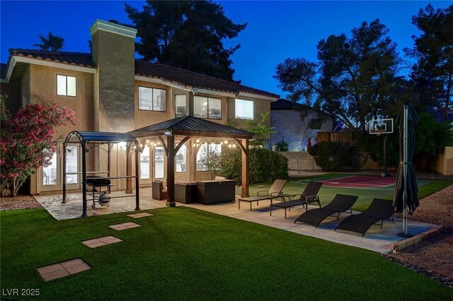 2224 Lucerne Ct, Henderson, NV 89014 - back of house at twilight with a gazebo, stucco siding, a yard, and a chimney