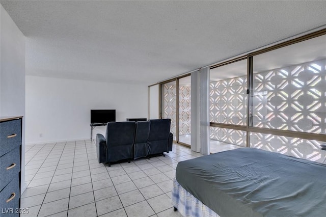 bedroom with light tile patterned floors, multiple windows, and a textured ceiling