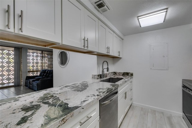 kitchen featuring stainless steel dishwasher, a sink, white cabinetry, light stone countertops, and electric panel