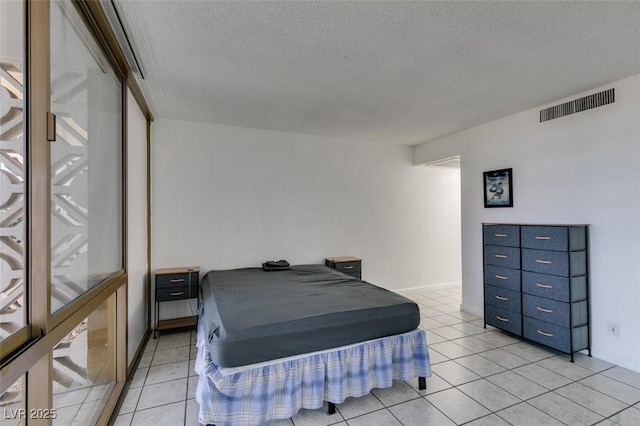 bedroom featuring a textured ceiling and light tile patterned floors