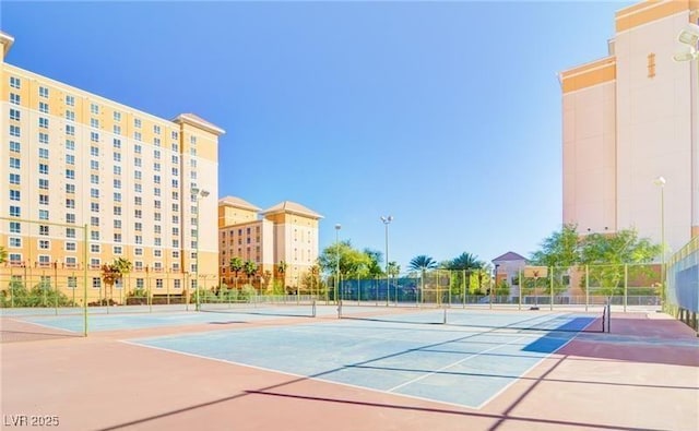 view of tennis court featuring fence and community basketball court