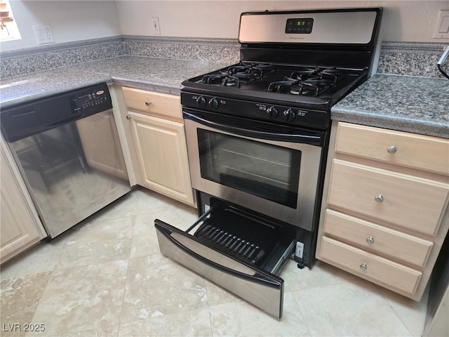 kitchen featuring stainless steel appliances, light brown cabinets, and dark countertops