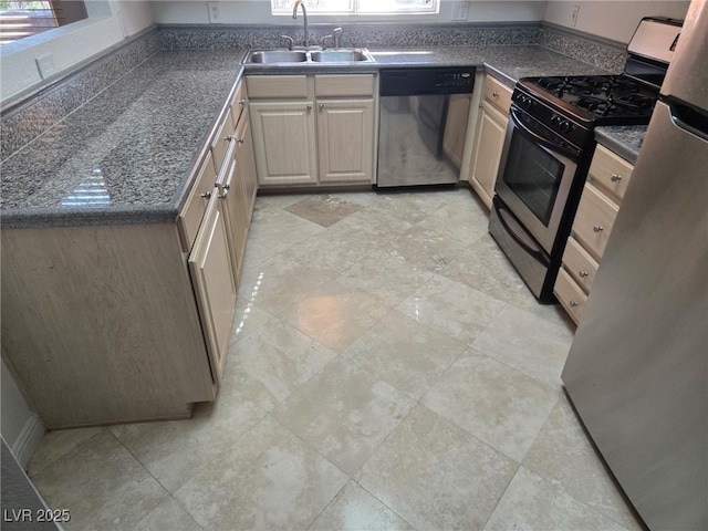 kitchen featuring stainless steel appliances, a sink, dark countertops, and light brown cabinetry