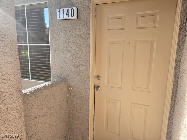 view of exterior entry with stucco siding