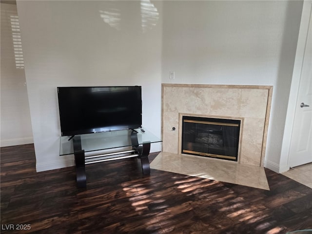 detailed view of wood finished floors, a fireplace, and baseboards