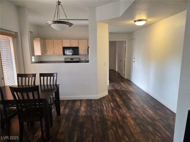 dining room featuring dark wood-style flooring and baseboards