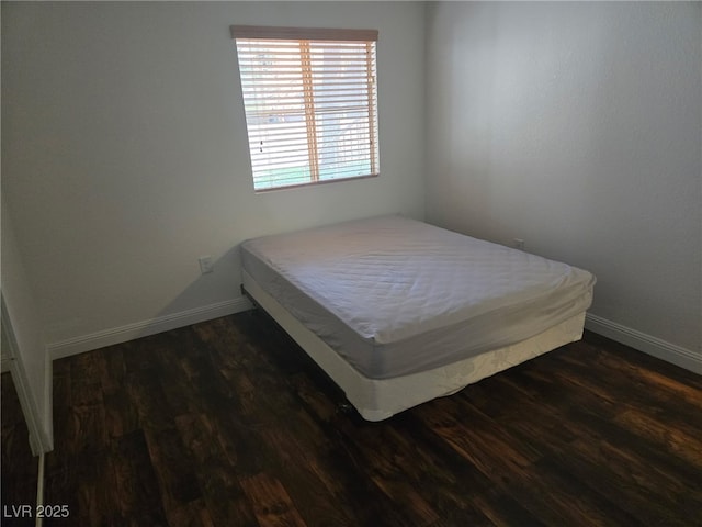 bedroom with wood finished floors and baseboards