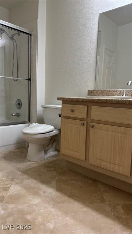 full bath with toilet, enclosed tub / shower combo, and vanity