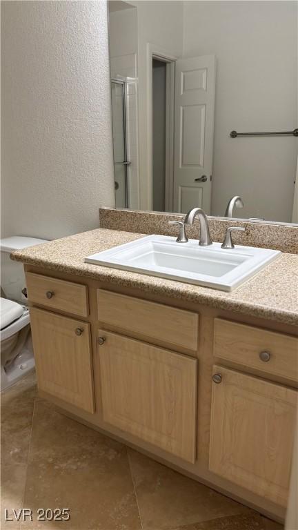 bathroom featuring a stall shower, toilet, tile patterned floors, and vanity