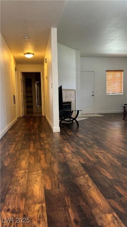 unfurnished living room featuring baseboards and wood finished floors