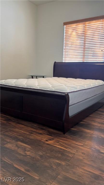 bedroom with dark wood-type flooring