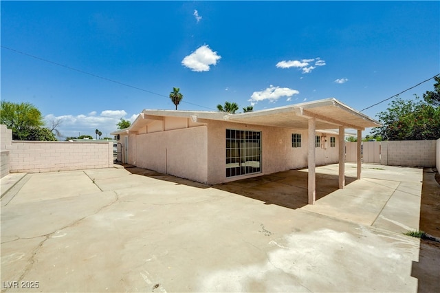 back of property with a patio, fence, and stucco siding