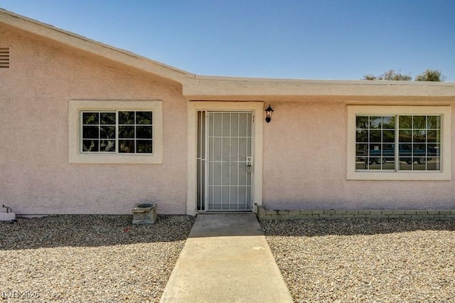 entrance to property with stucco siding