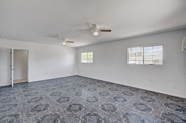 empty room featuring ceiling fan and baseboards