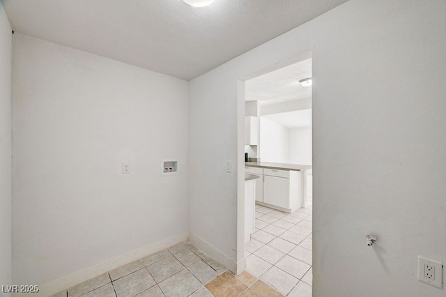 laundry area featuring washer hookup, light tile patterned flooring, and baseboards