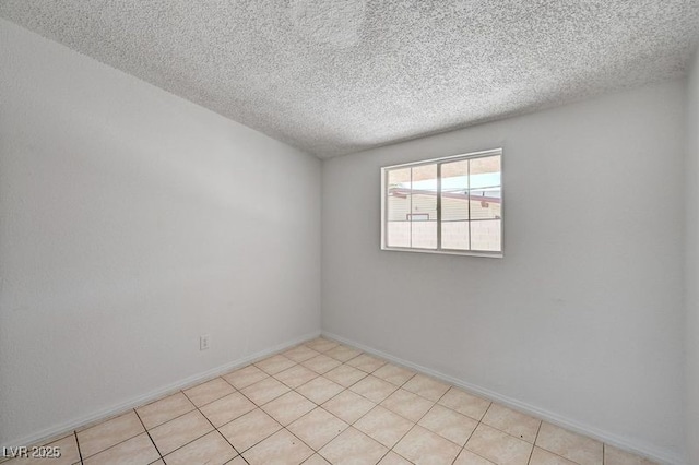 unfurnished room featuring a textured ceiling and baseboards