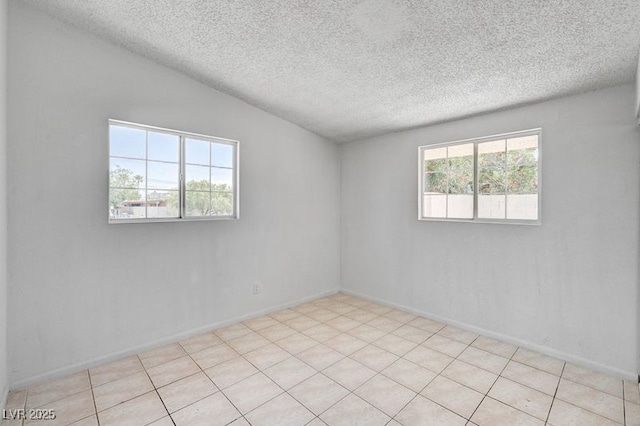 empty room featuring a textured ceiling and baseboards