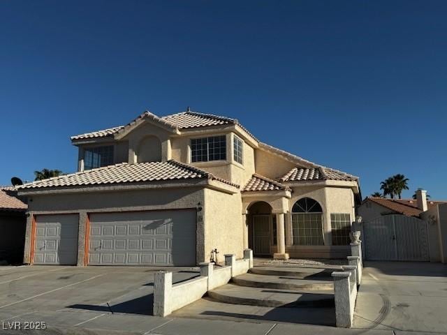 529 Rancho Del Mar Way N, Las Vegas, NV 89031 - mediterranean / spanish house with a gate, an attached garage, a tile roof, stucco siding, and driveway