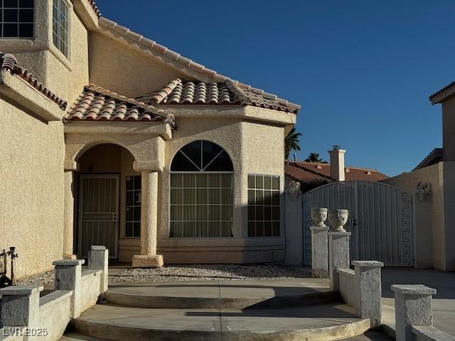 529 Rancho Del Mar Way N, Las Vegas, NV 89031 - property entrance with a gate, stucco siding, and a tiled roof