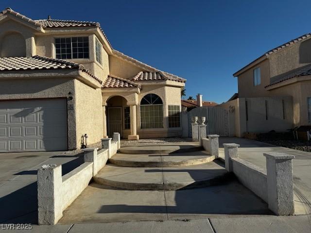 529 Rancho Del Mar Way N, Las Vegas, NV 89031 - view of front of home with a tile roof, stucco siding, concrete driveway, an attached garage, and a gate
