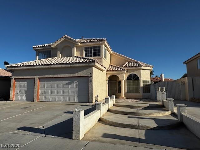 529 Rancho Del Mar Way N, Las Vegas, NV 89031 - mediterranean / spanish-style house with an attached garage, a tile roof, concrete driveway, stucco siding, and fence