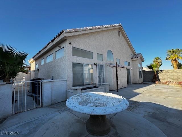 529 Rancho Del Mar Way N, Las Vegas, NV 89031 - back of house with a patio, a fenced backyard, stucco siding, a tiled roof, and a gate