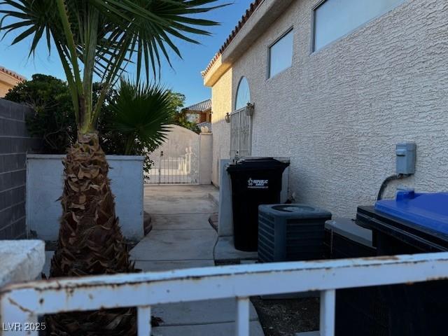 529 Rancho Del Mar Way N, Las Vegas, NV 89031 - view of home's exterior with stucco siding, fence, a gate, and cooling unit