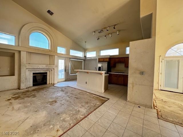529 Rancho Del Mar Way N, Las Vegas, NV 89031 - unfurnished living room with high vaulted ceiling, a glass covered fireplace, and light tile patterned floors