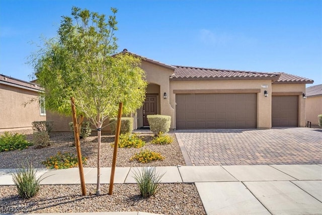 3708 Fuselier Dr, North Las Vegas, NV 89032 - mediterranean / spanish-style home featuring an attached garage, decorative driveway, a tile roof, and stucco siding
